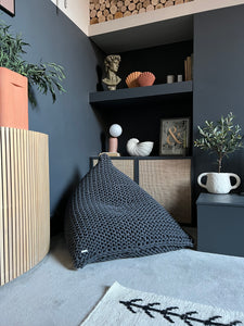 Grey knitted beanbag chair in modern dark grey living room 